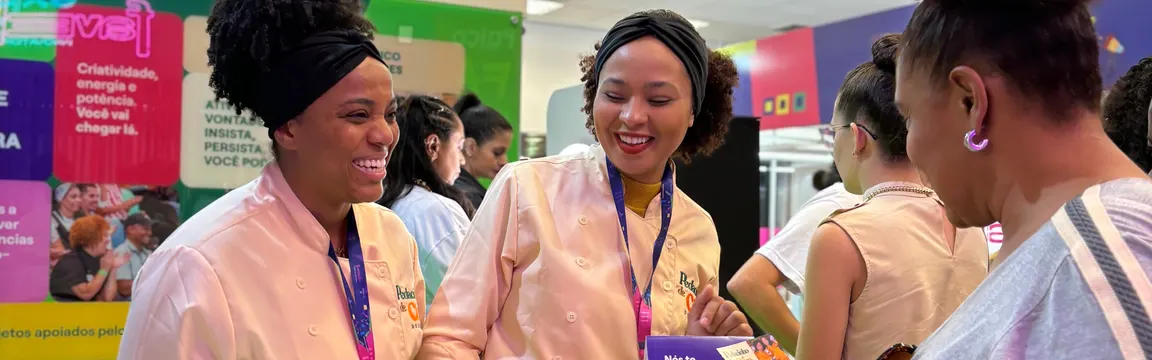 Empreendedoras sorrindo durante um evento de exposição