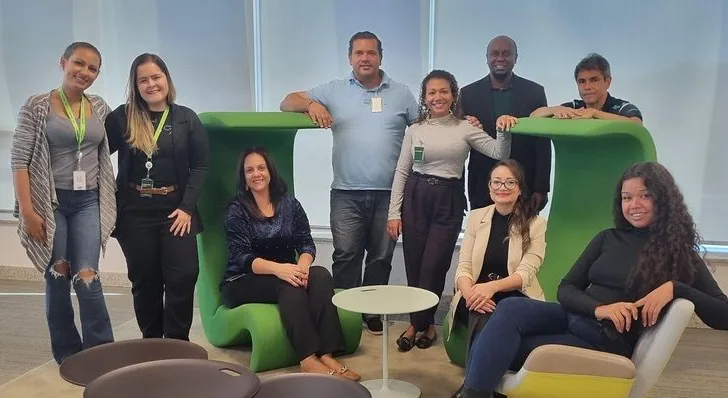 Grupo de participantes do programa reunido em um ambiente corporativo