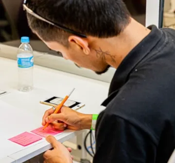 Jovem escrevendo durante uma atividade do projeto