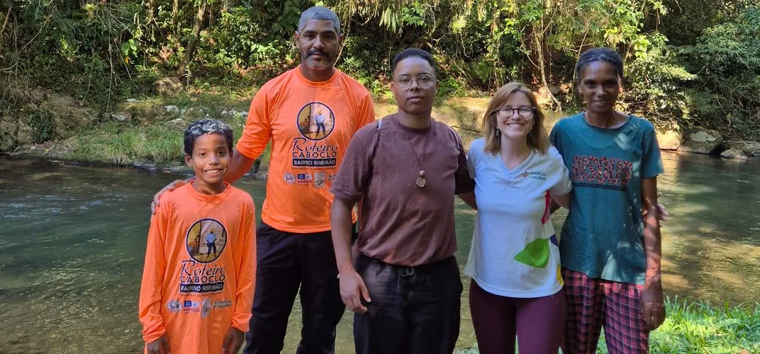 Grupo em um roteiro à beira do rio, com camisetas do Roteiro Caboclo