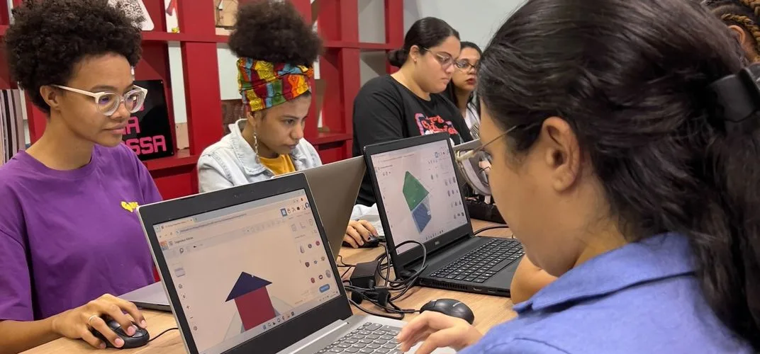 Jovens trabalhando em laptops em um espaço de formação