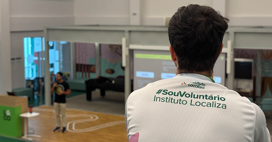 Dupla de voluntários conversando em frente a um notebook