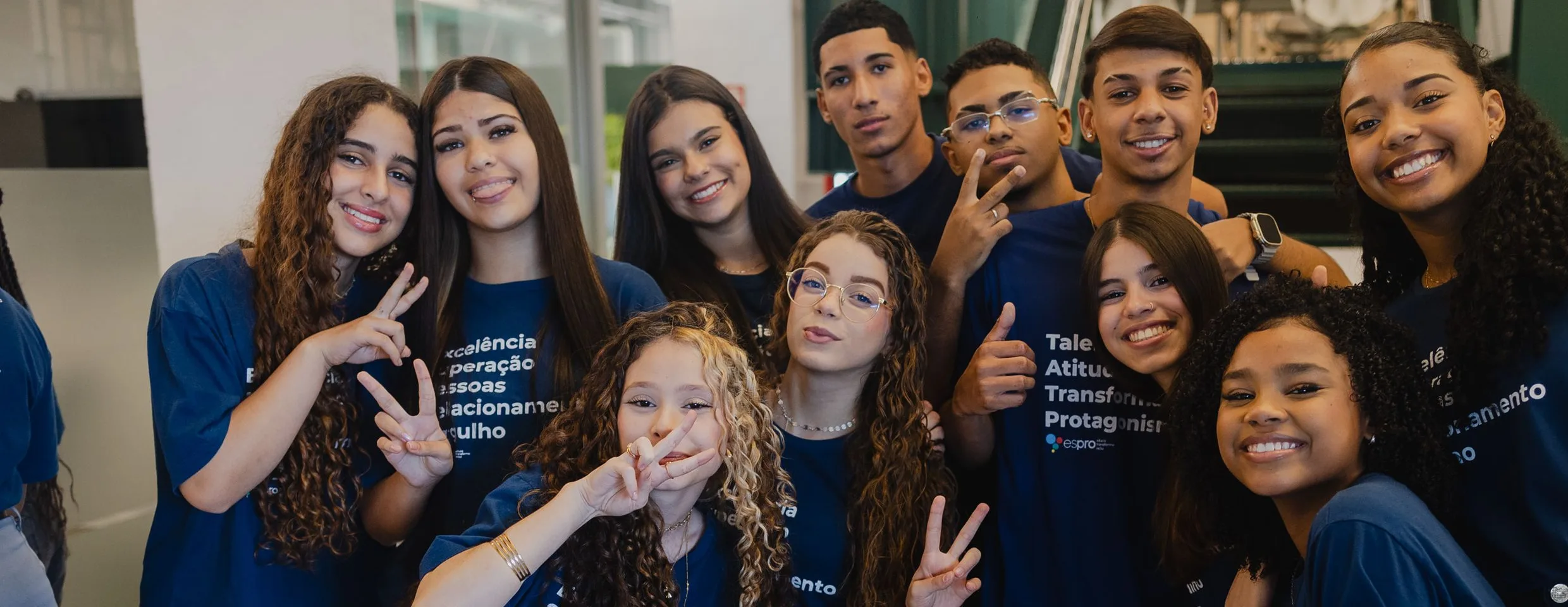 Grupo de jovens sorrindo com camisetas do programa Espro