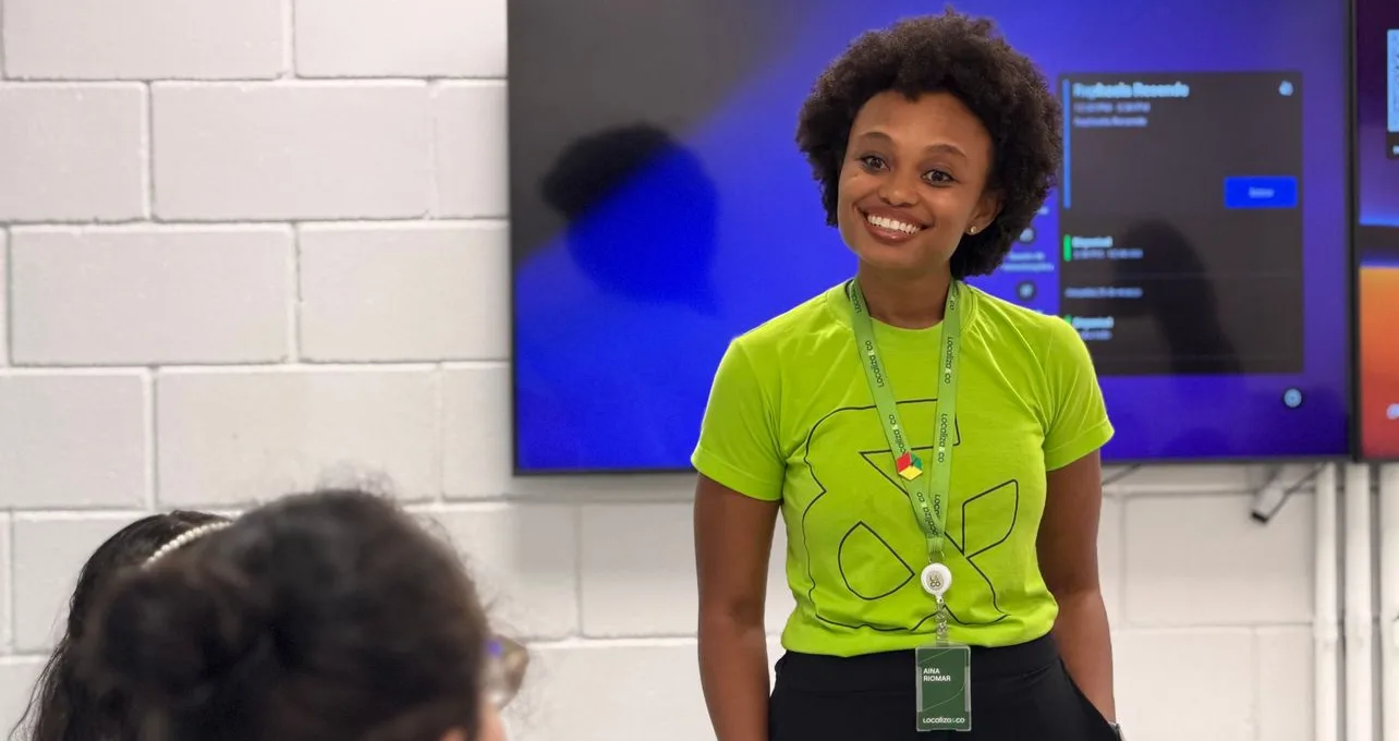Voluntária sorrindo em uma sala, com a camiseta verde do Instituto Localiza